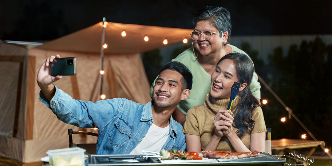 A family is gathered to take a photo at a summer night barbecue.